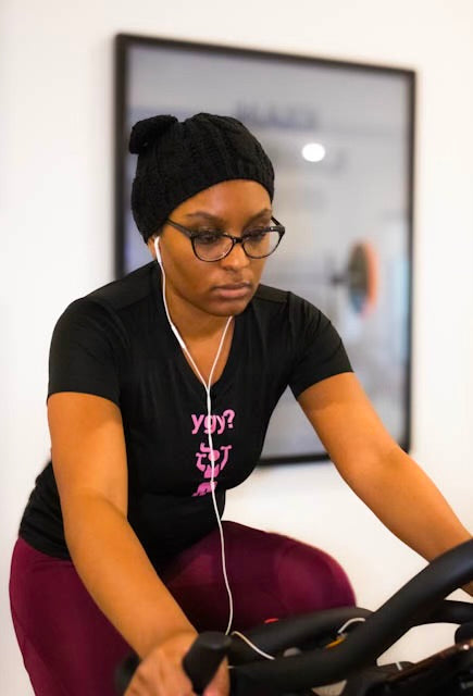 A photo of a young woman on an exercise bike